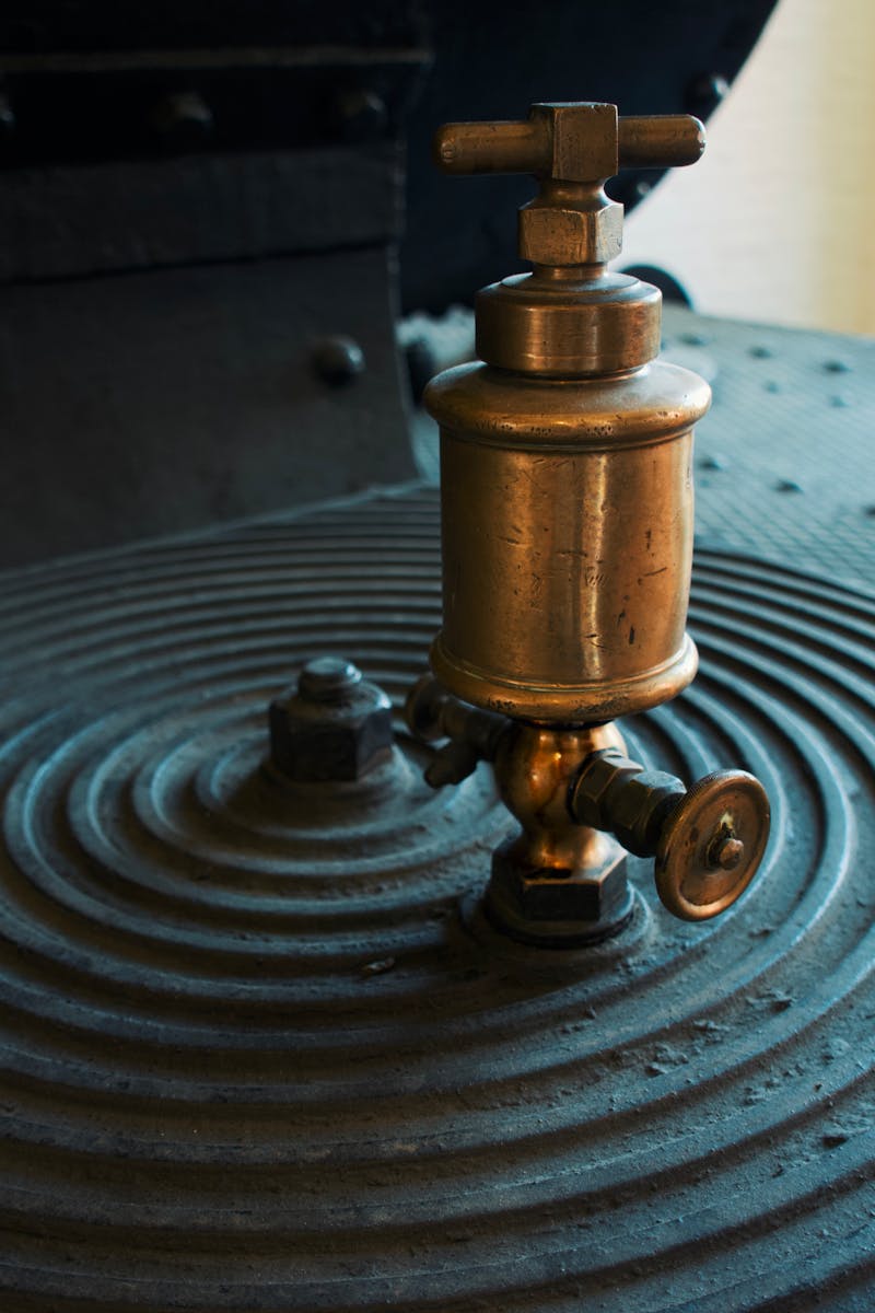 Close-up of a vintage brass valve on an industrial machine surface